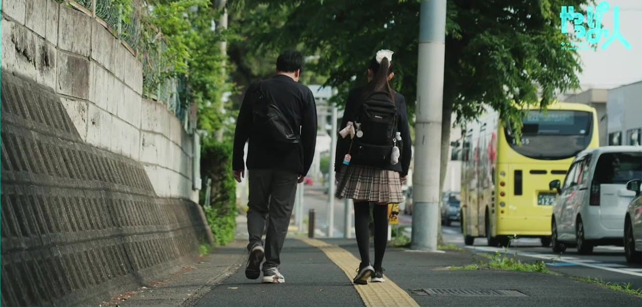 点字ブロックのある歩道を並んで歩く、鈴木さんと歩行訓練士の髙田さん